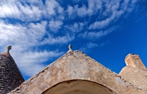 An abandoned trullo below blue autumn skies.
