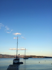 As twilight approaches, sailboats appear to float on the glassy surface of the Ionian sea in this quiet bay on Paxos.